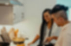 Couple serving roast potatoes in the kitchen